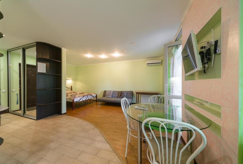 a living room with a table and chairs and a bedroom at Iordanska Street Apartments in Kyiv