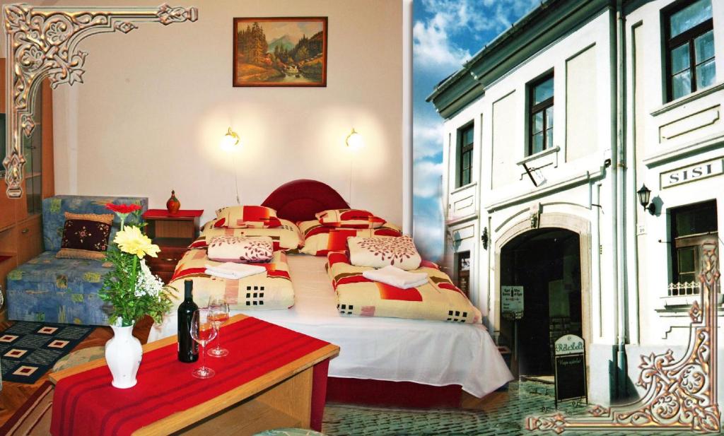- une chambre avec un lit doté d'oreillers rouges et jaunes dans l'établissement Arany Barokk Apartman, à Eger