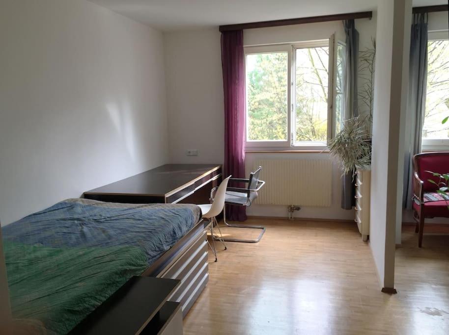 Schlafzimmer mit einem Schreibtisch, einem Bett und einem Tisch in der Unterkunft Room in maisonette with garden, parking place in Wien