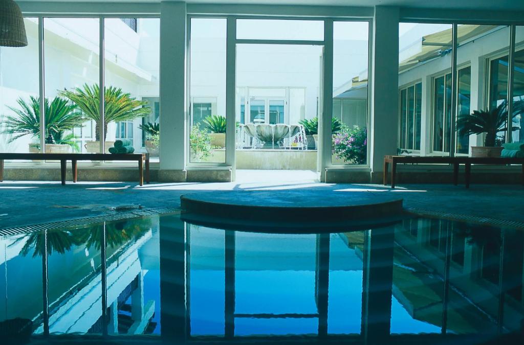 a pool in a building with a table in the middle at Anassa in Polis Chrysochous