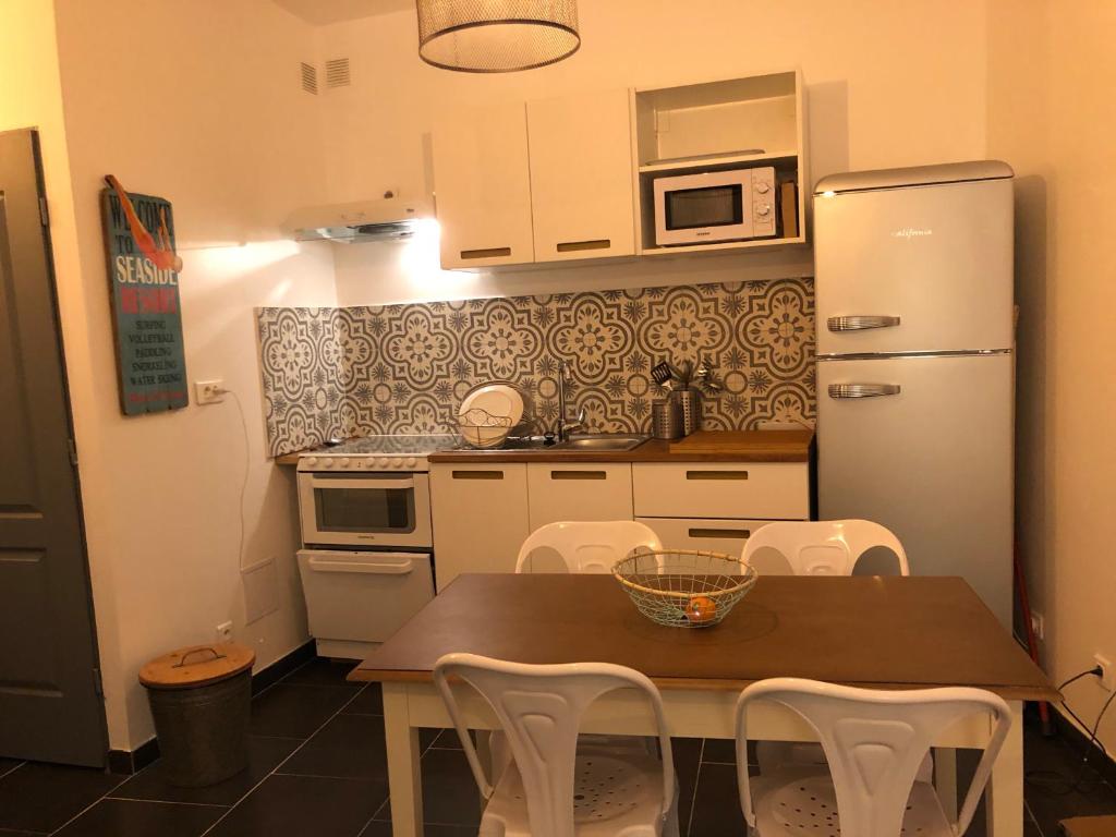 a kitchen with a table and a refrigerator at La Bulle in Cassis