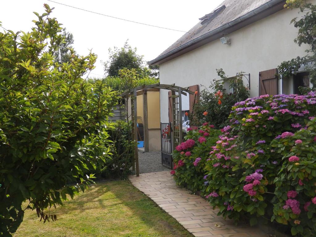una casa con una puerta y flores en el patio en Gîte La MER, en Commes