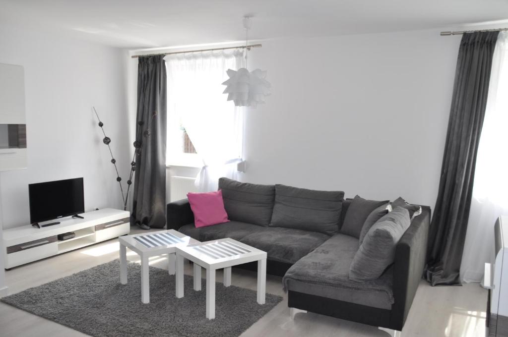 een woonkamer met een bank en een tafel bij Apartament Wilenska in Mrągowo