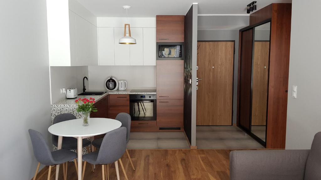 a small kitchen with a white table and chairs at New apartment 100m from old town and marina in Gdańsk