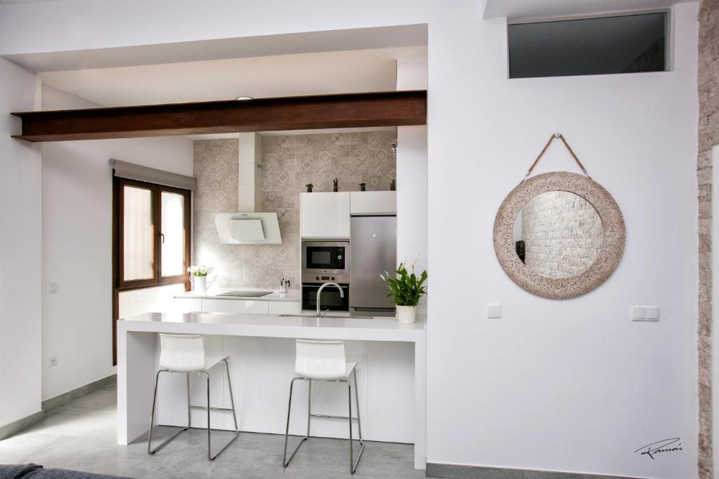 a kitchen with a white counter and stools at La Pandorga in Sanlúcar de Barrameda