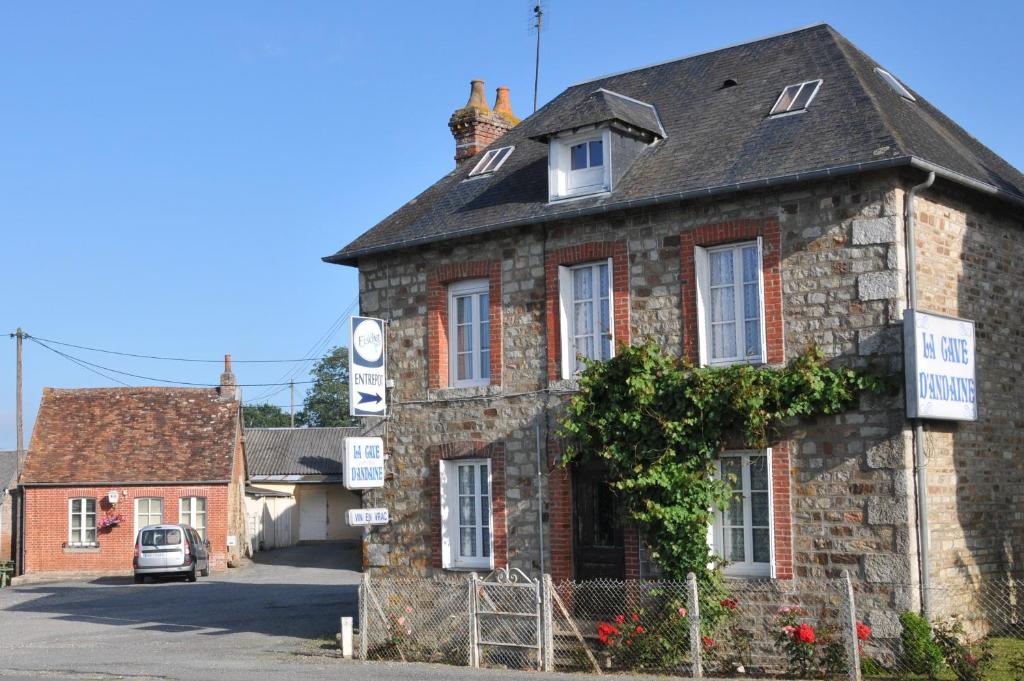 - un vieux bâtiment en pierre avec un panneau dans l'établissement Maison de famille rustique Durée de location 7 jours minimum 1 chien maximum, à Saint-Michel-des-Andaines