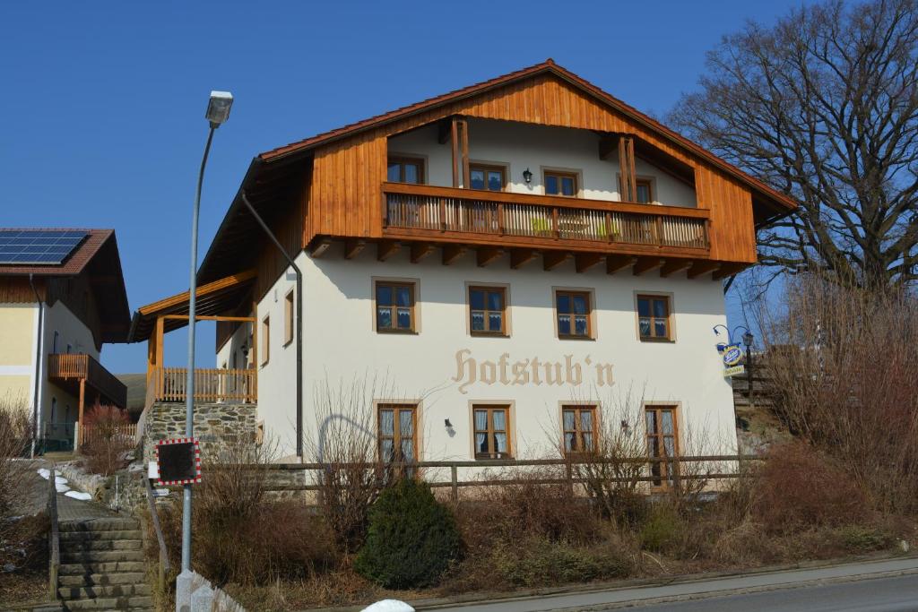 um grande edifício branco com um telhado de madeira em Hofstub´n em Eschlkam
