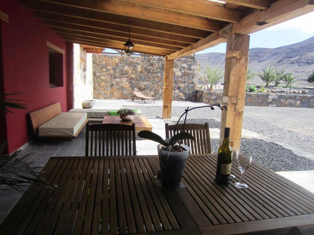 a wooden table with a bottle of wine on a patio at Casa Perenquén in La Pared
