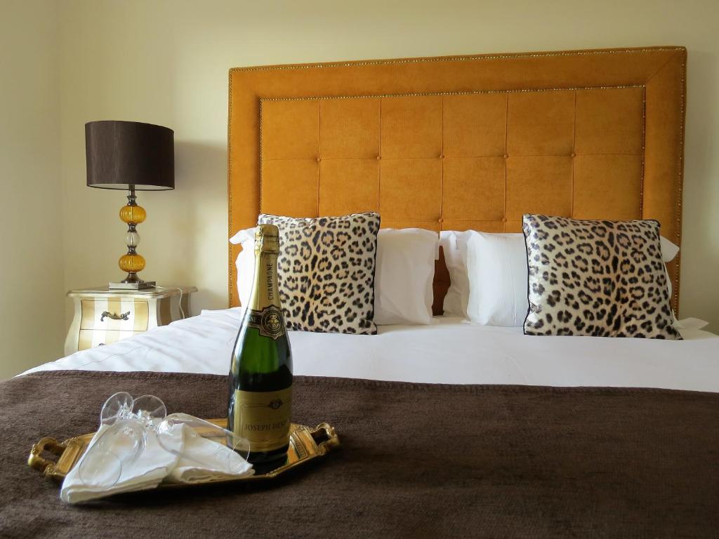 a bottle of champagne and a bag on a bed at Sea Moments Apartments in Portimão