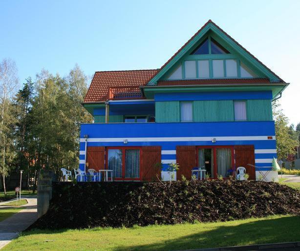 a blue house with chairs in front of it at Apartmán Adam in Lipno nad Vltavou