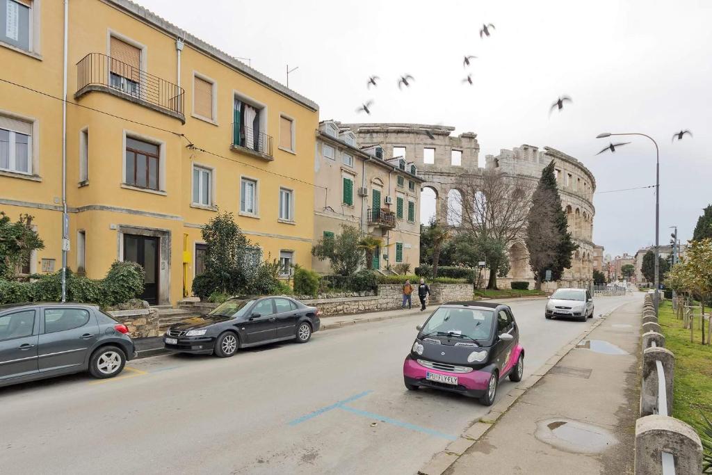 um grupo de carros estacionados numa rua com edifícios em Apartment Nicol em Pula