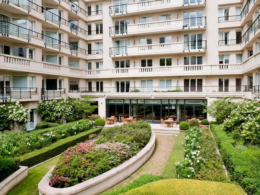 a large building with a garden in front of it at Aparthotel Paris 15 Porte de Versailles in Issy-les-Moulineaux