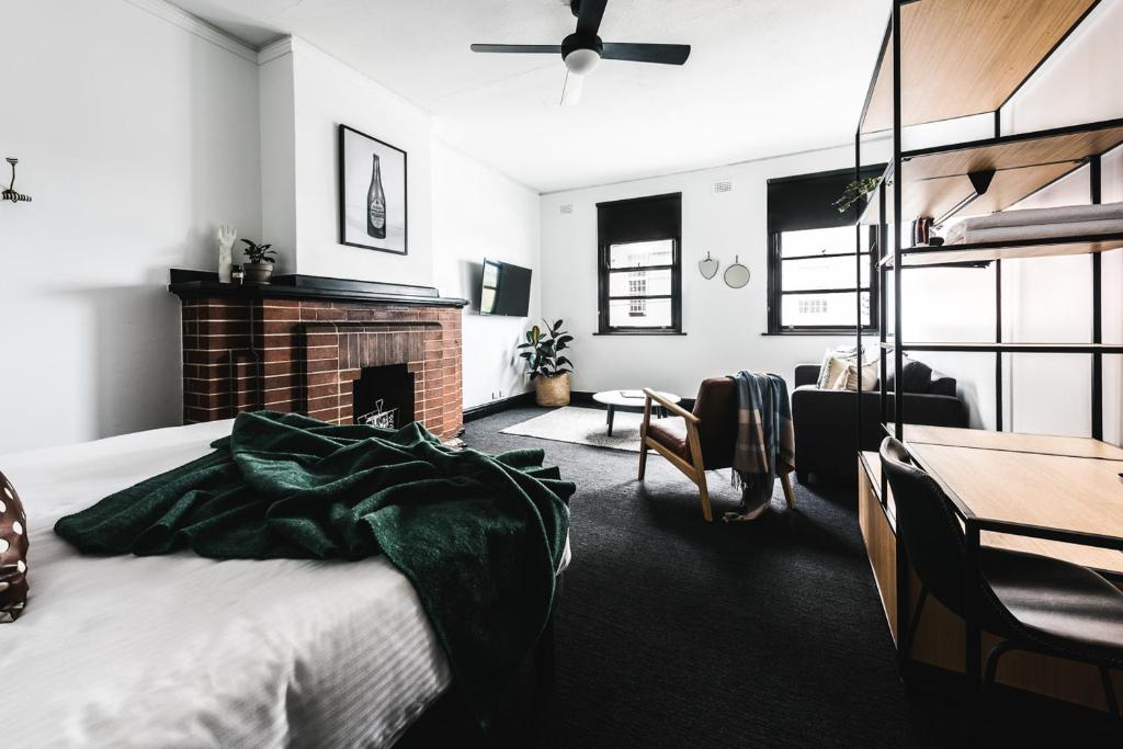 a bedroom with a bed and a fireplace and a table at Sydney Park Hotel in Sydney