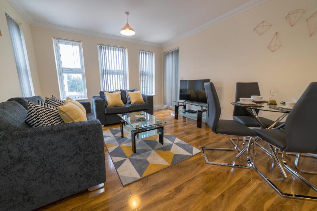 een woonkamer met een bank en een tafel bij London Heathrow Serviced Apartments in Stanwell