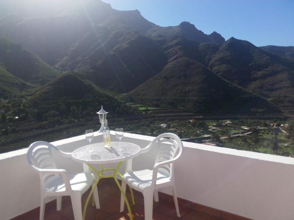 un tavolo e sedie su un balcone con vista sulle montagne di Makondo ad Agaete
