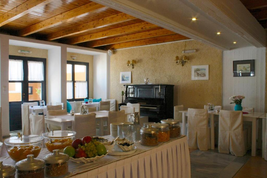 a dining room with a table with food on it at Mare Vista Hotel - Epaminondas in Batsi