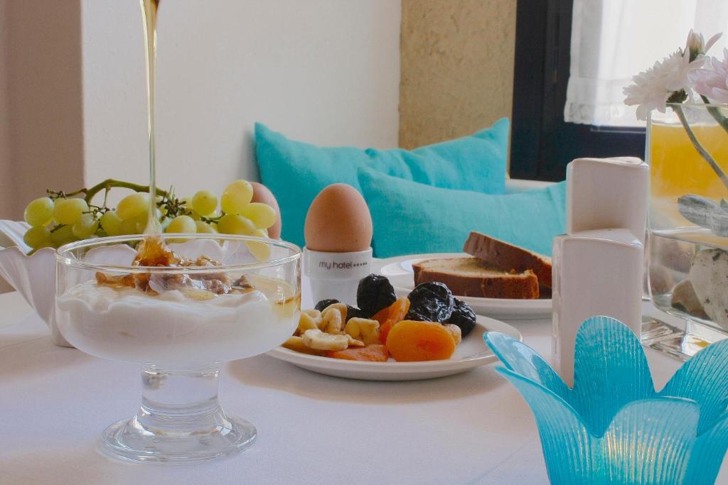 a table with a bowl of food and a plate of fruit at Mare Vista Hotel - Epaminondas in Batsi