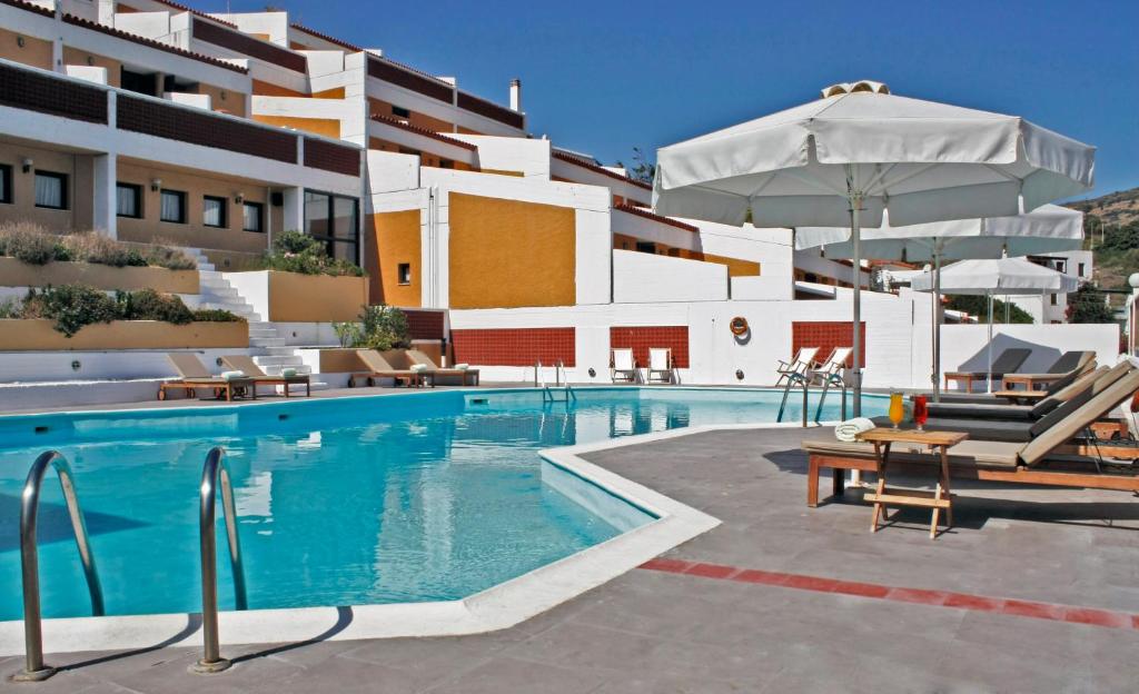 a swimming pool in front of a building at Mare Vista Hotel - Epaminondas in Batsi