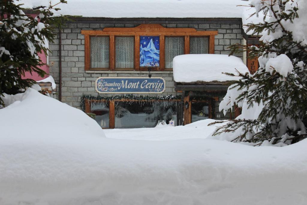 a building with a sign in the snow at Chambres Mont Cervin in Breuil-Cervinia