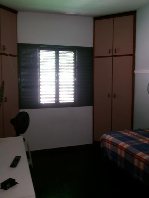 a bedroom with a window and a bed and a desk at Quartos Masculino - Romas House in Itu