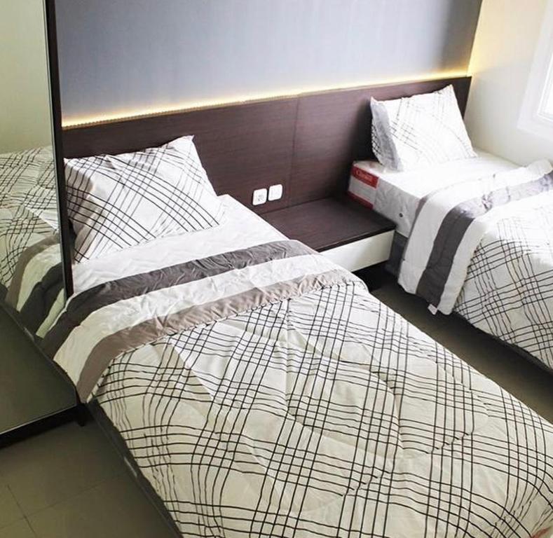 two beds sitting next to each other in a room at Sam’s Parahyangan Residence in Bandung