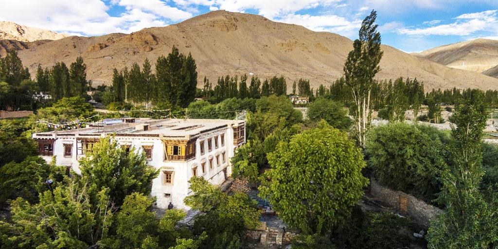 an aerial view of a building with trees and mountains at Nimmu House Ladakh in Nimu