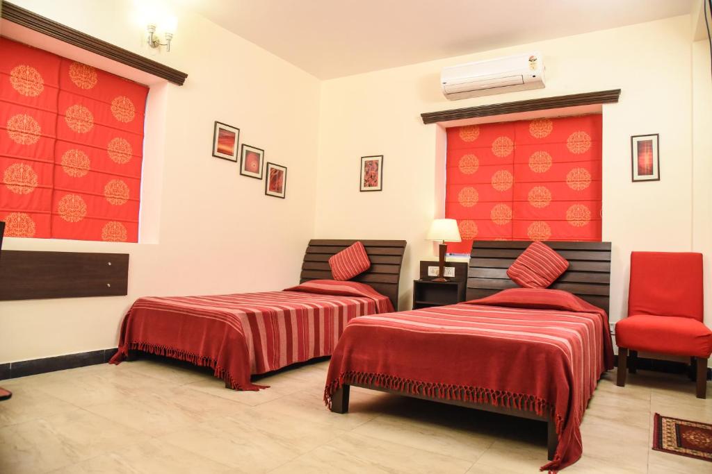 a room with two beds and a red wall at Red Arrow Residency in Kolkata