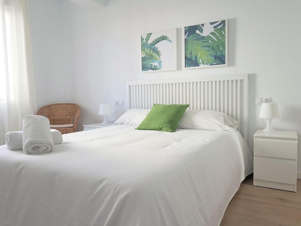 バレンシアにあるTranvia a la Playa Malvarrosaの白いベッド(上に緑の枕付)