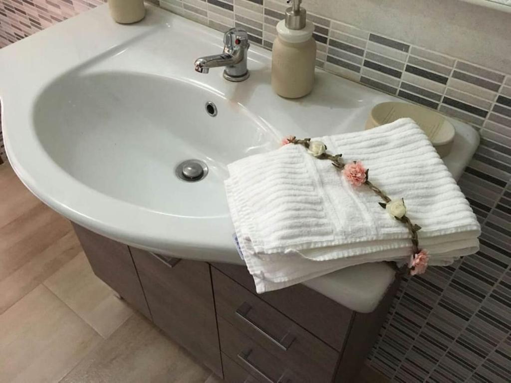 un lavandino in bagno con un asciugamano bianco di Casa Il Nuraghe a Monserrato