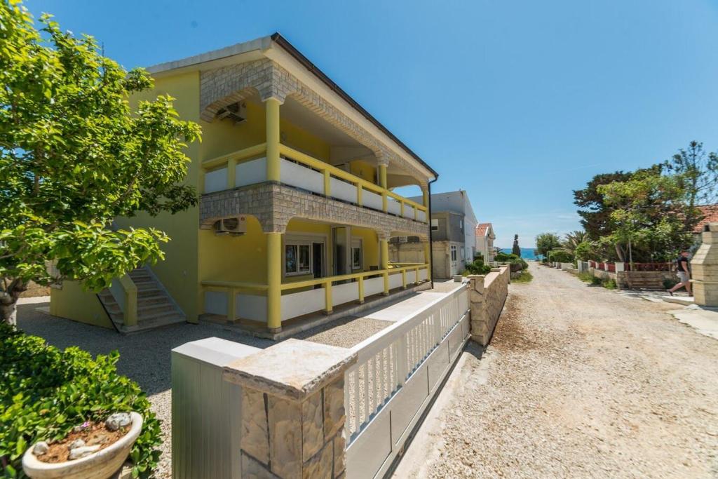 ein gelbes Haus am Straßenrand in der Unterkunft Apartments VAM in Vir