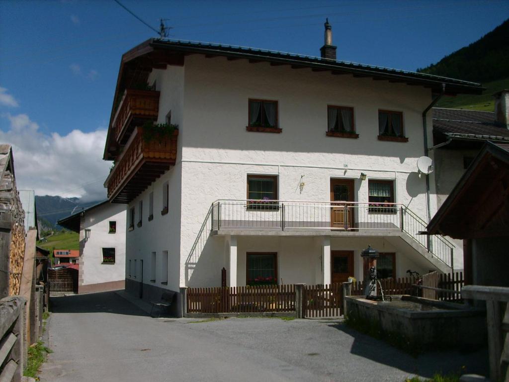 ein weißes Haus mit Balkon auf einer Straße in der Unterkunft Apart Panoramablick in Nauders