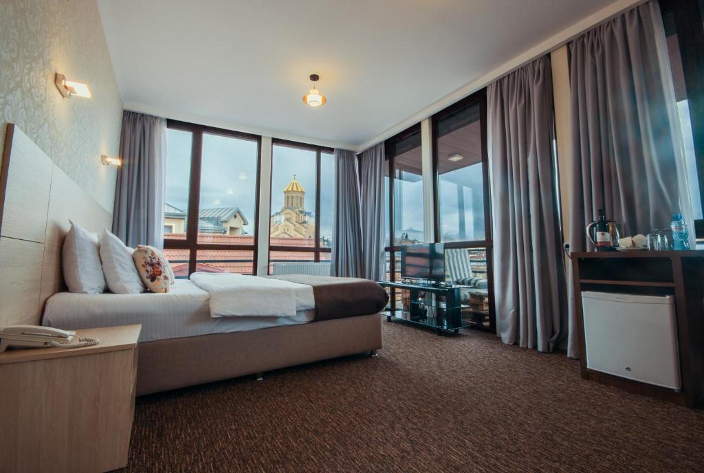 a hotel room with a bed and a large window at Light House Old City in Tbilisi City