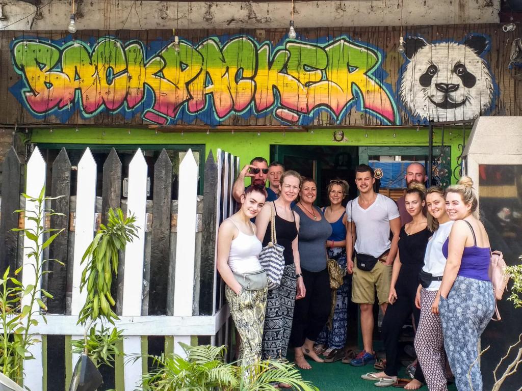 a group of people standing in front of a building with graffiti at Backpackers Villa Mumbai in Mumbai