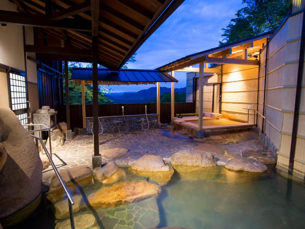 a pool of water with rocks in front of a building at Arima Onsen Motoyu Ryuusenkaku in Kobe