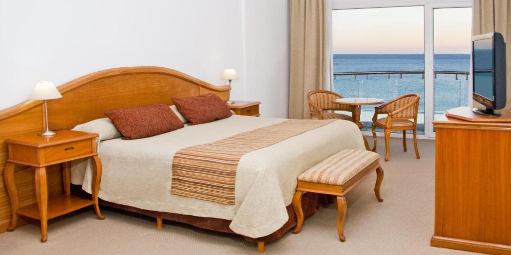 a bedroom with a bed with a view of the ocean at Hotel Piren in Puerto Madryn