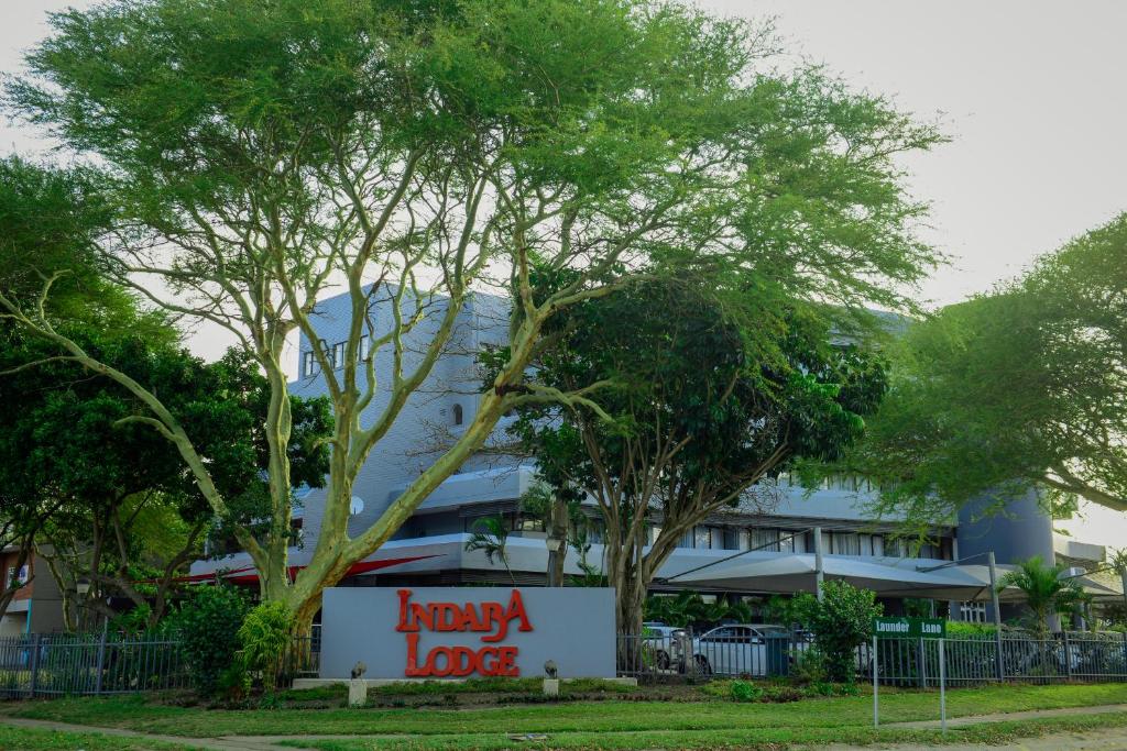 un edificio con una feliz señal de arrendamiento delante de él en Indaba Lodge Hotel Richards Bay, en Richards Bay