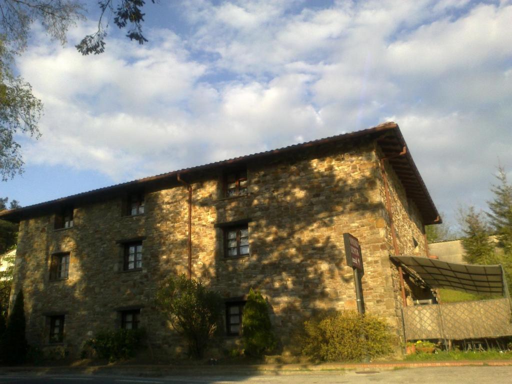 un antiguo edificio de piedra al lado de la carretera en Mañuko Benta, en Bermeo