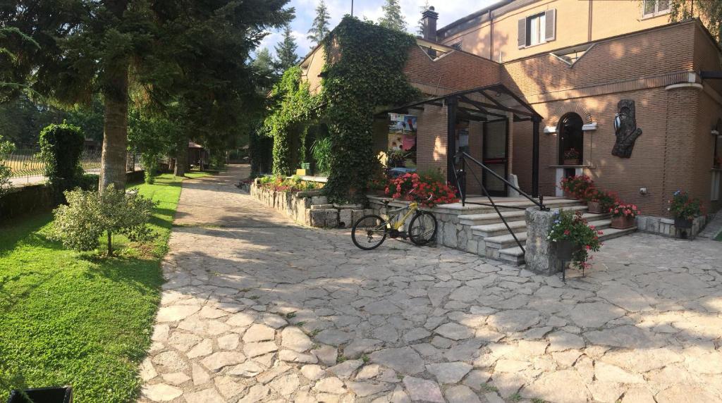 rower zaparkowany przed domem z kwiatami w obiekcie LH Albergo il Picchio w mieście Pescasseroli