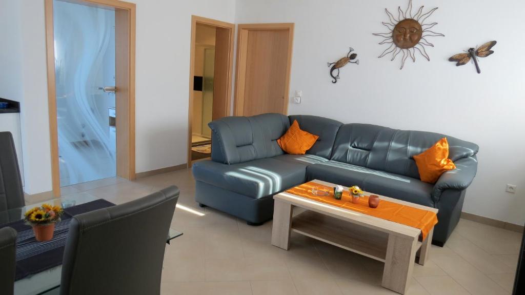 ein Wohnzimmer mit einem blauen Sofa und einem Tisch in der Unterkunft "Schoene Aussicht" in Burgen