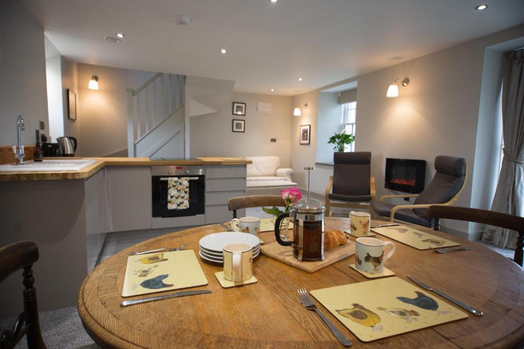 a dining room and living room with a wooden table at Cairn Leuchan in Ballater