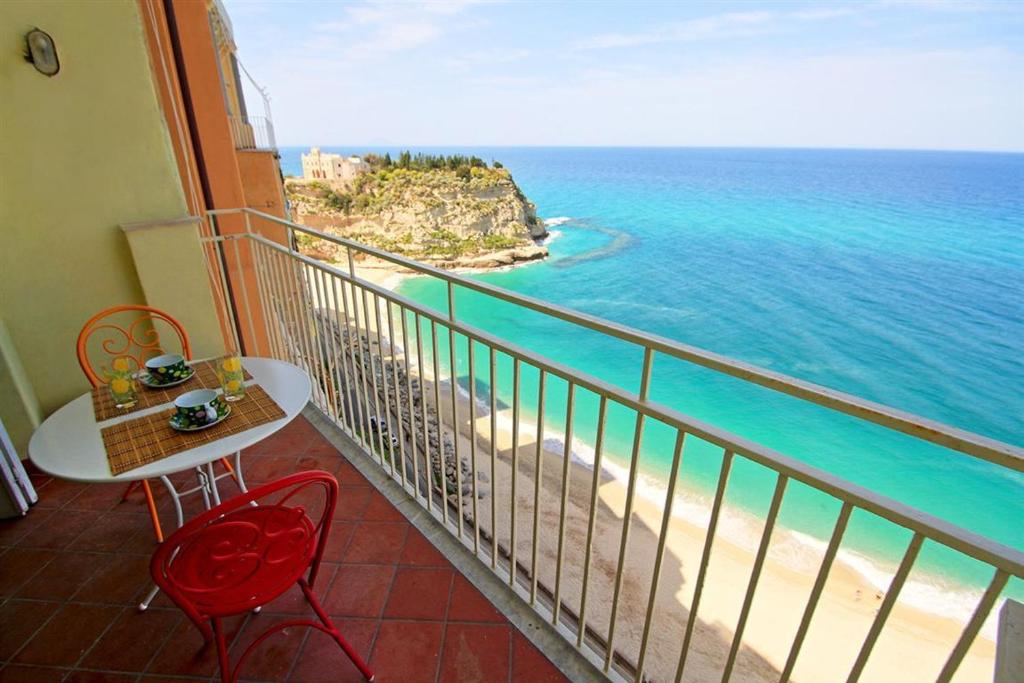 balcone con tavolo, sedie e vista sull'oceano di Isola Bella Sea-view Apartment a Tropea