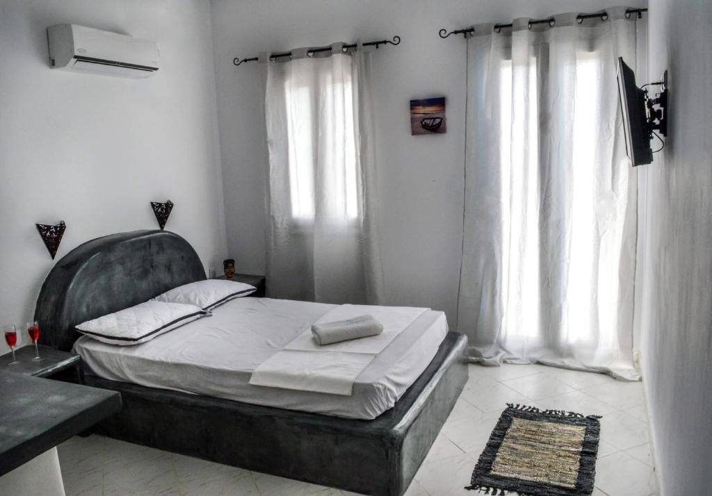 a bedroom with a bed and a large window at Santo Margarita in Oia