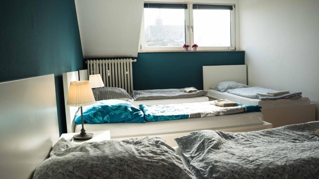 ノイスにあるFerienwohnung Neussのベッド3台と窓が備わる客室です。
