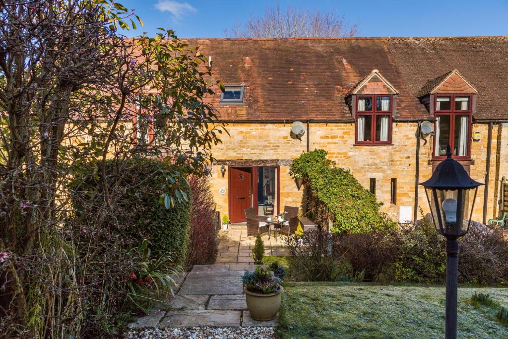 a brick house with a red door and a street light at Ratty's Retreat in Blockley