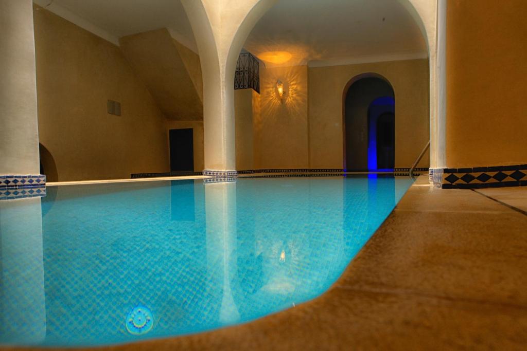 a swimming pool with blue water in a building at Lina Ryad & Spa in Chefchaouene