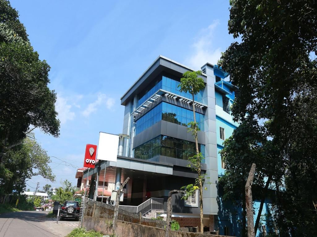 um edifício azul com árvores em frente em Sophiya Suites em Cochin