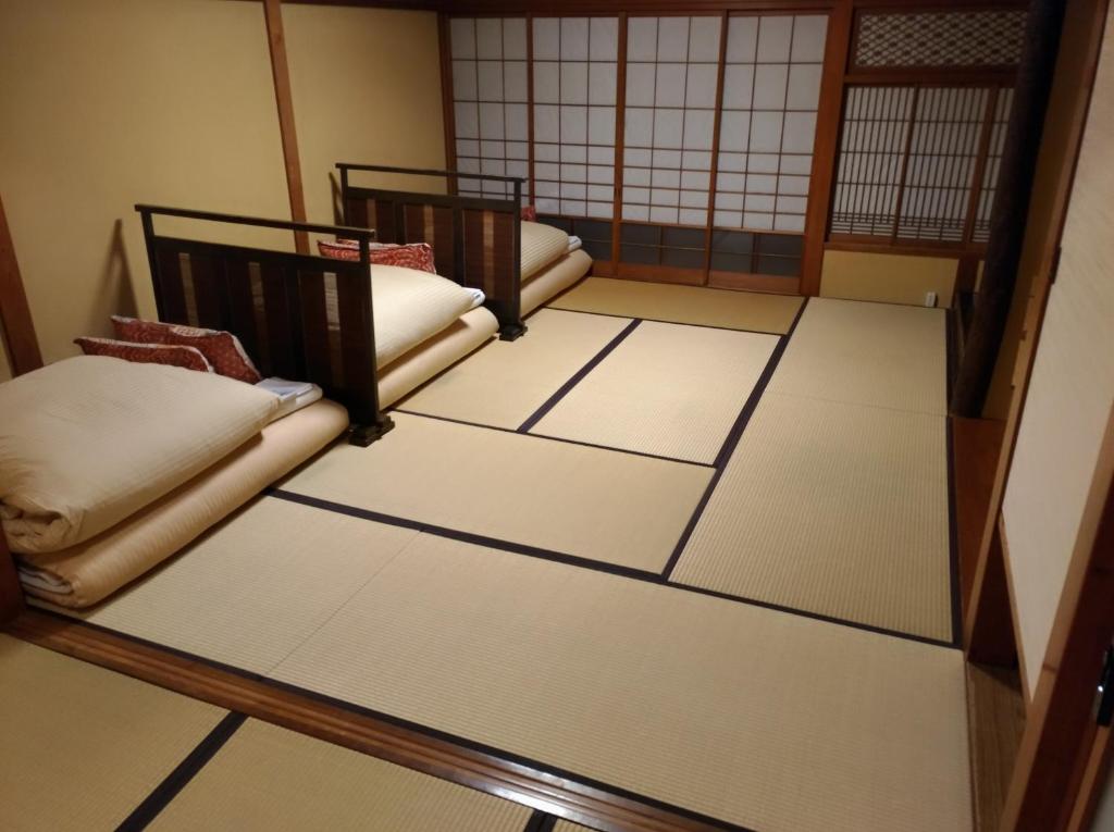 Postel nebo postele na pokoji v ubytování K's House Ito Onsen - Historical Ryokan Hostel