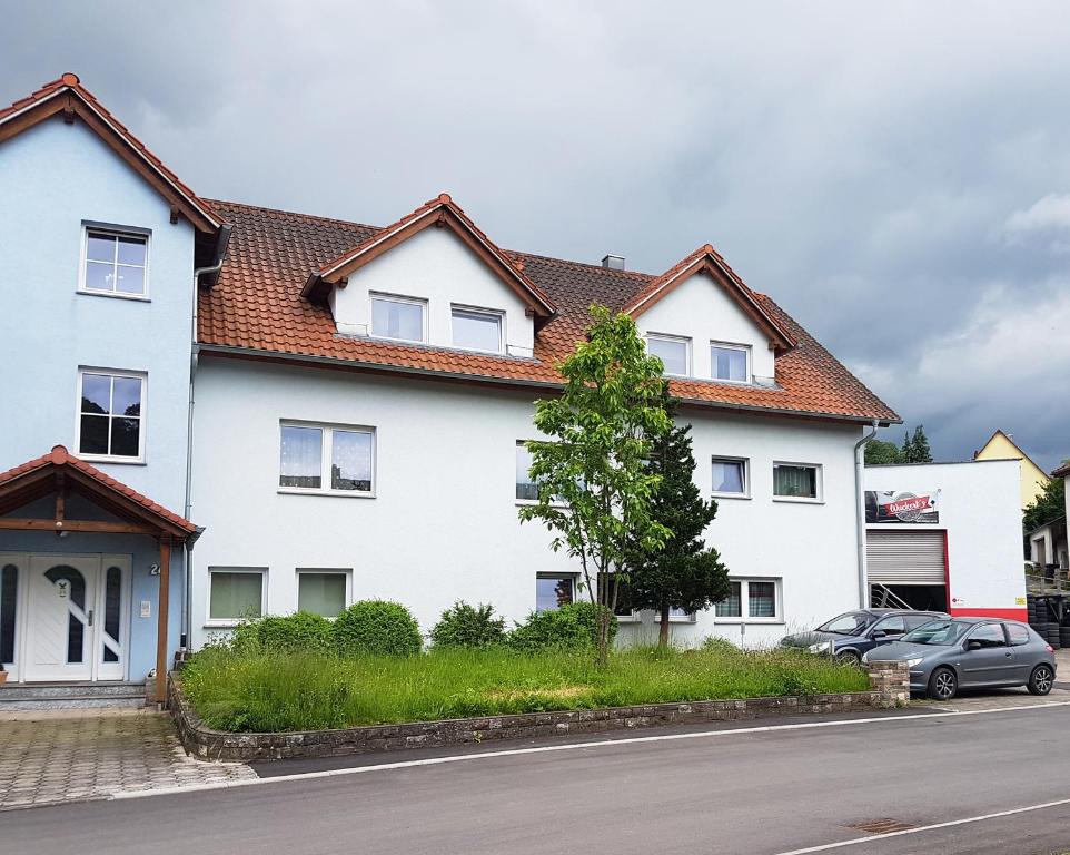 una casa blanca con un coche aparcado delante de ella en Monteurzimmer Obersulm en Obersulm
