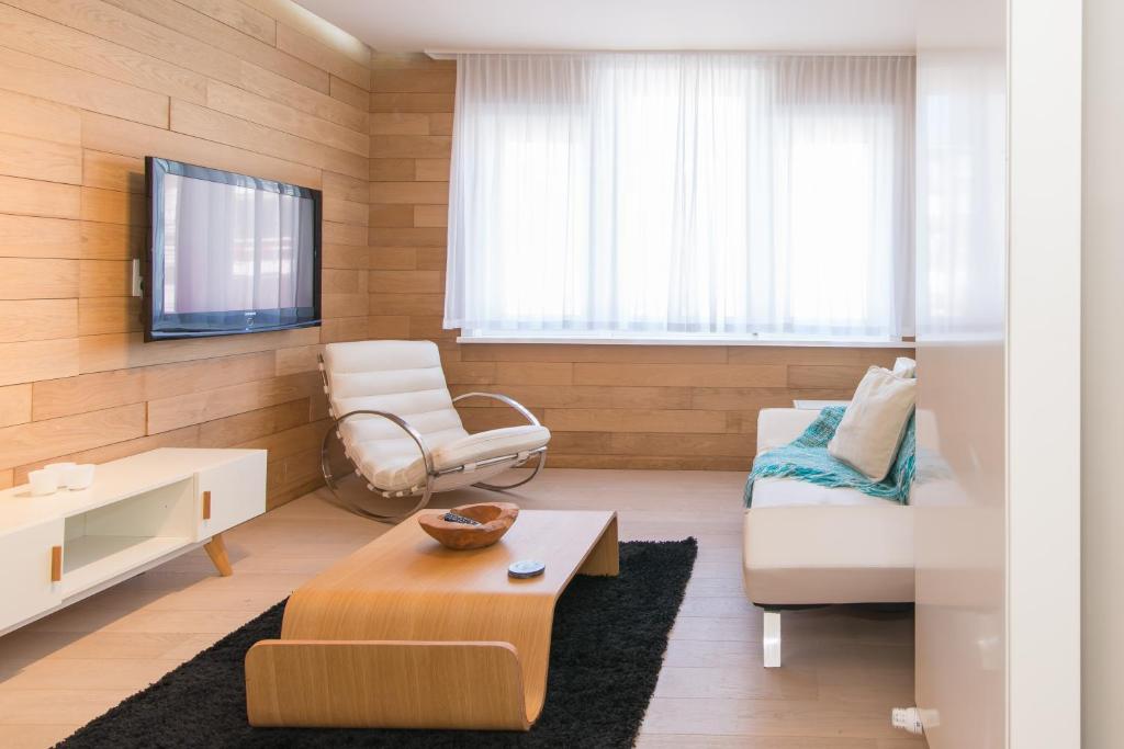 a living room with a couch and a tv at Duplex in De Panne
