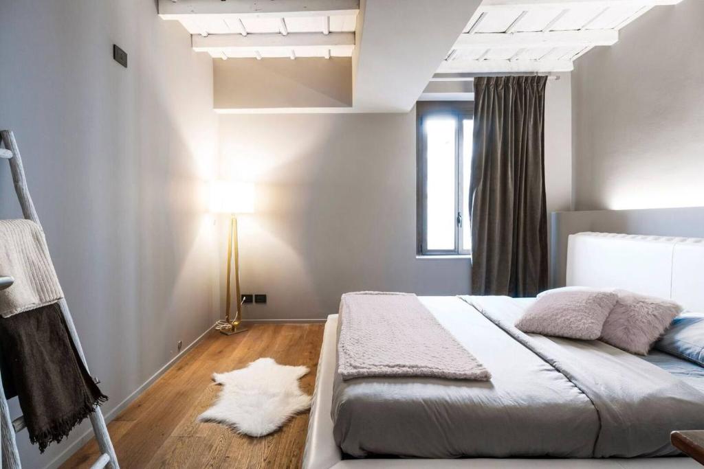 a white bedroom with a bed and a lamp at My Lovely Place Navigli in Milan